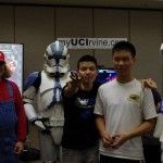 An IEEE member poses with a raffle winner while Mario and stormtroopers look on.